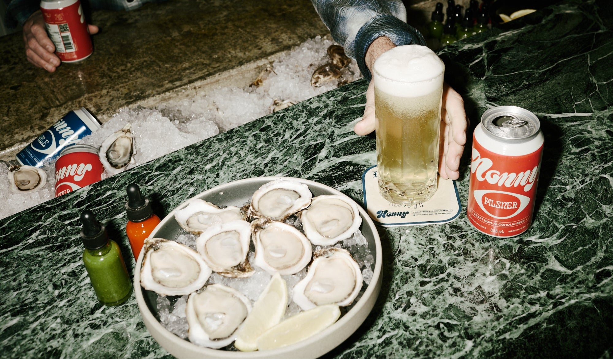 Nonny Craft Non-Alcoholic Beer being served in a pint glass with oysters.
